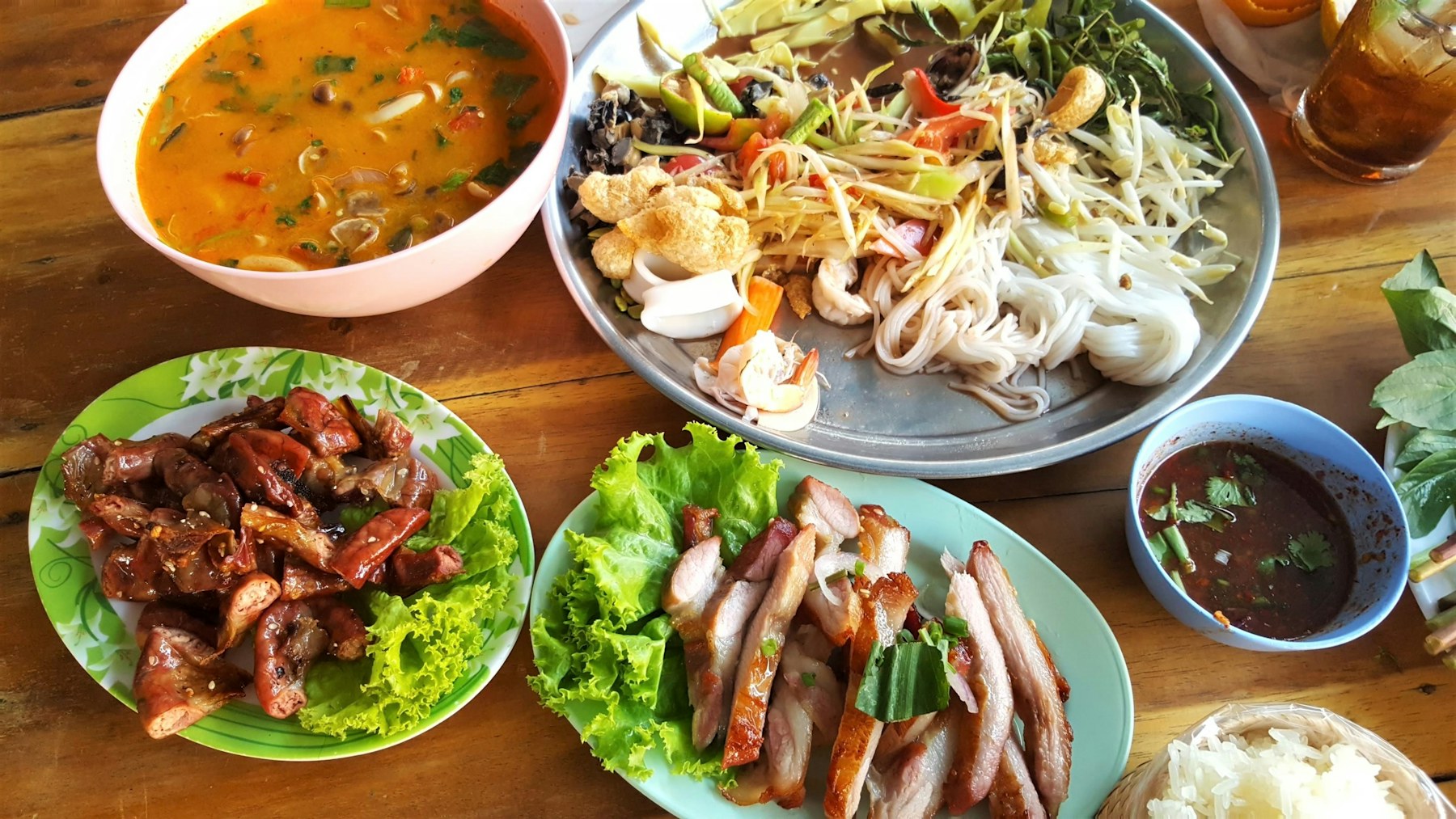 โต๊ะอาหารไทยแบบเหนือ มีซุป ต้มยำ ส้มตำ และหมูย่าง